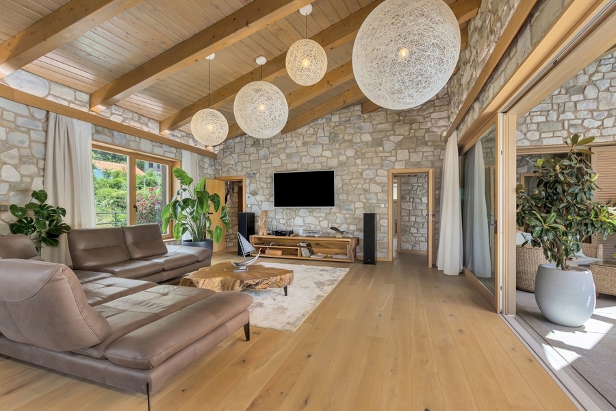 Salon avec mur en pierre naturelle et télévision
