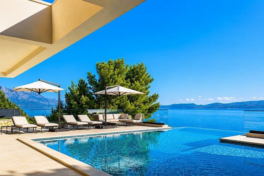 Terrasse de la piscine avec bains de soleil et vue mer