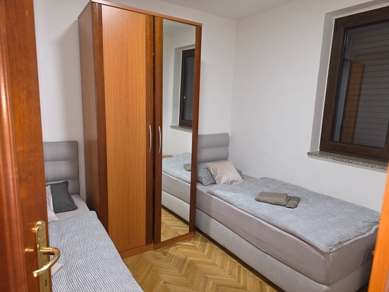 Chambre avec deux lits simples et armoire