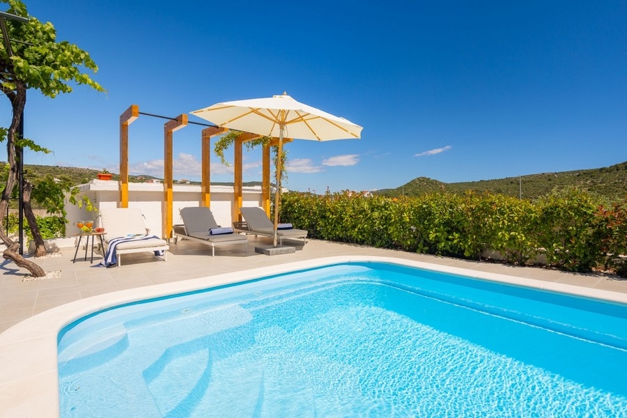 Piscine avec bains de soleil et pergola