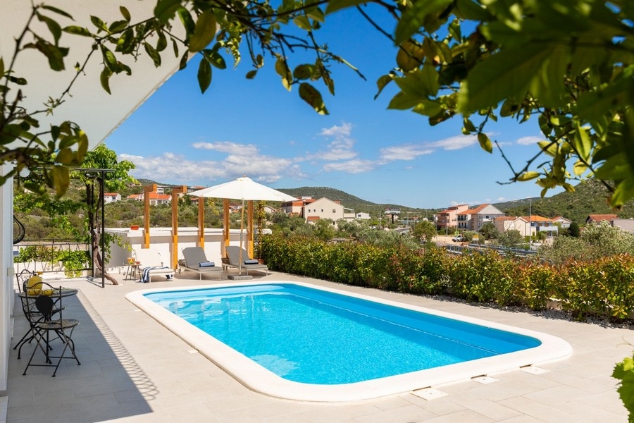 Terrasse de la piscine avec parasols et transats