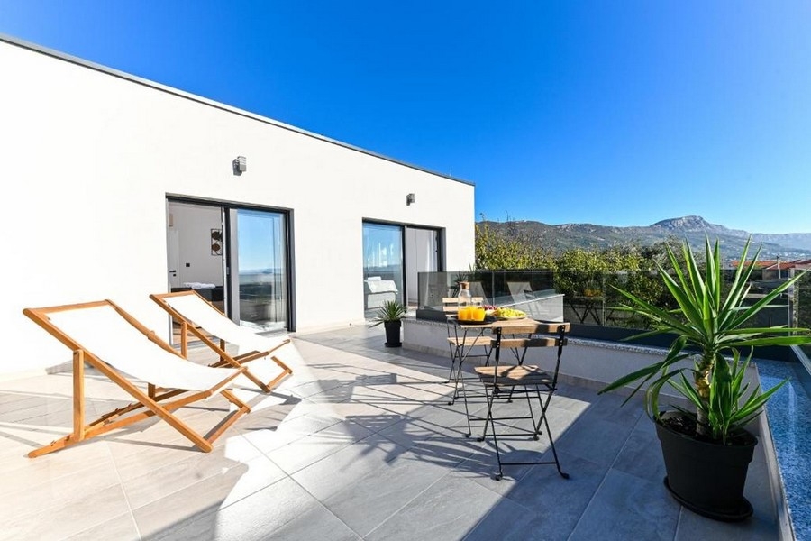 Terrasse solarium avec chaises longues et coin salon