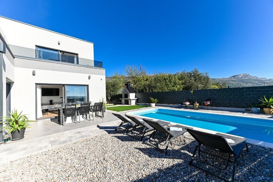 Espace extérieur avec piscine et coin salon couvert