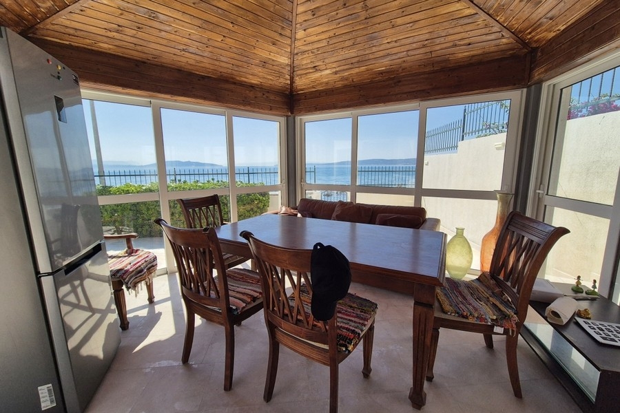 Cuisine d'été vitrée avec table à manger et vue mer en Croatie