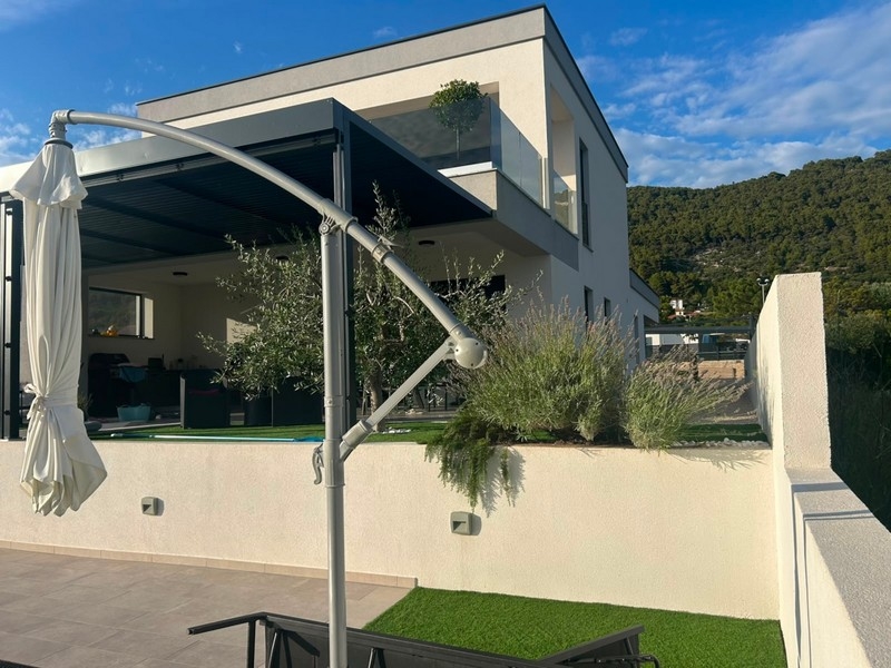 Terrasse couverte avec parasol à la maison neuve sur Rab