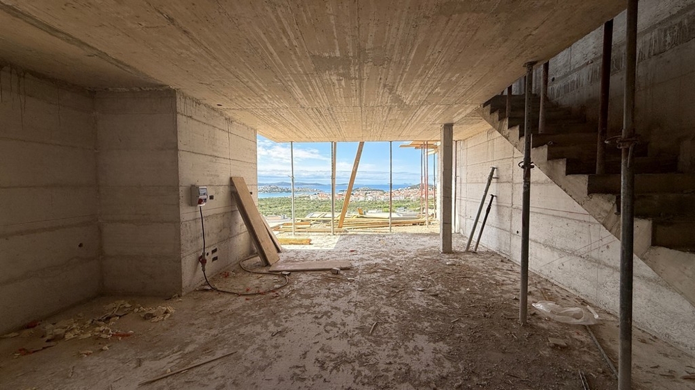 Intérieur en gros œuvre avec escalier et vue mer
