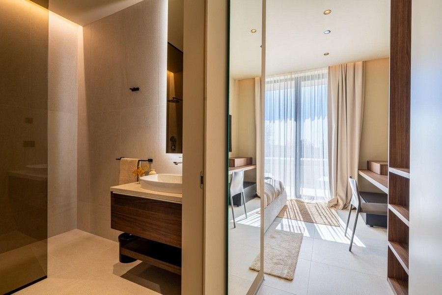 Salle de bains avec meuble vasque et vue sur la chambre
