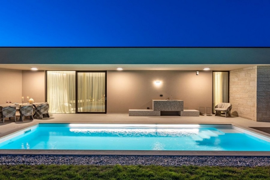 Piscine et terrasse éclairées de la villa près de Porec le soir