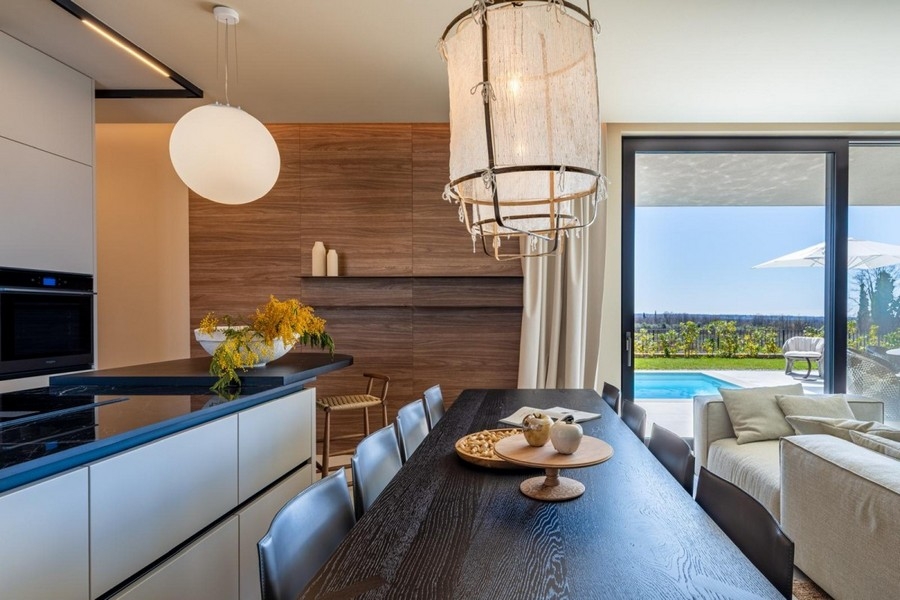 Cuisine avec îlot de cuisson et vue à travers la façade vitrée
