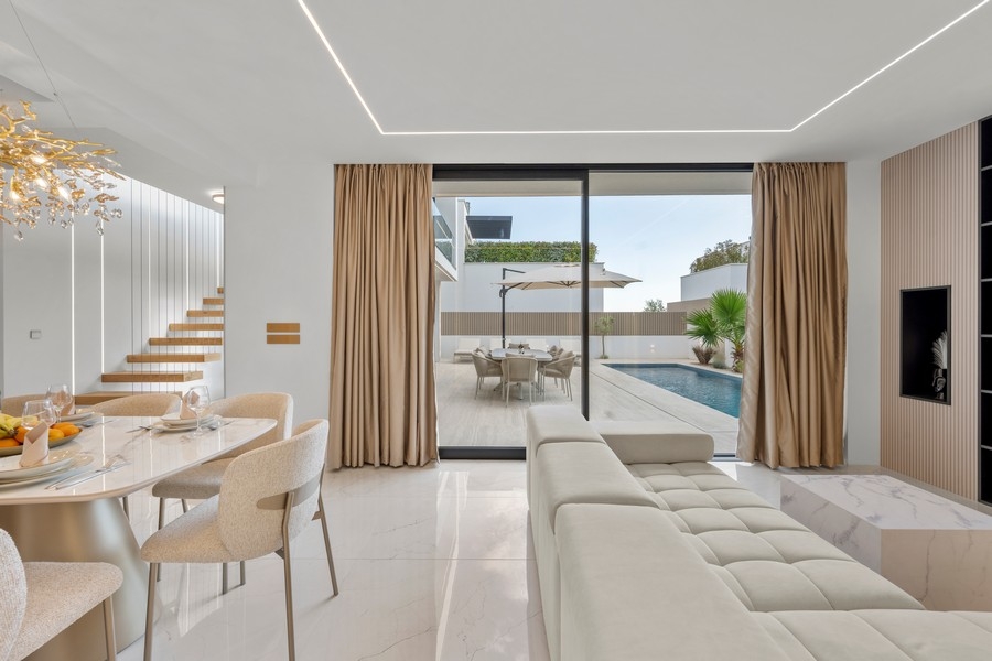 Salon avec canapé et accès à la terrasse de la piscine