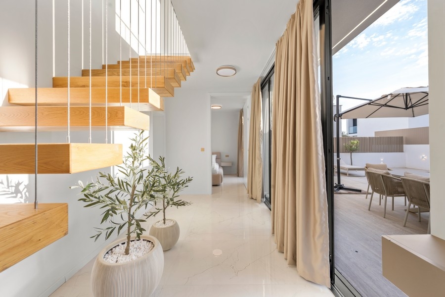Couloir avec escalier en bois et vue sur la terrasse
