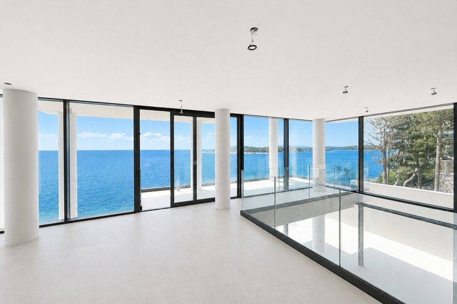 Séjour avec façades vitrées à hauteur d'étage et vue mer