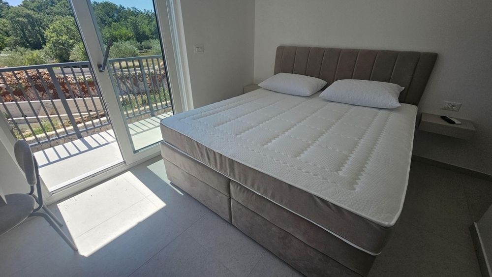 Chambre avec lit double et porte donnant sur le balcon