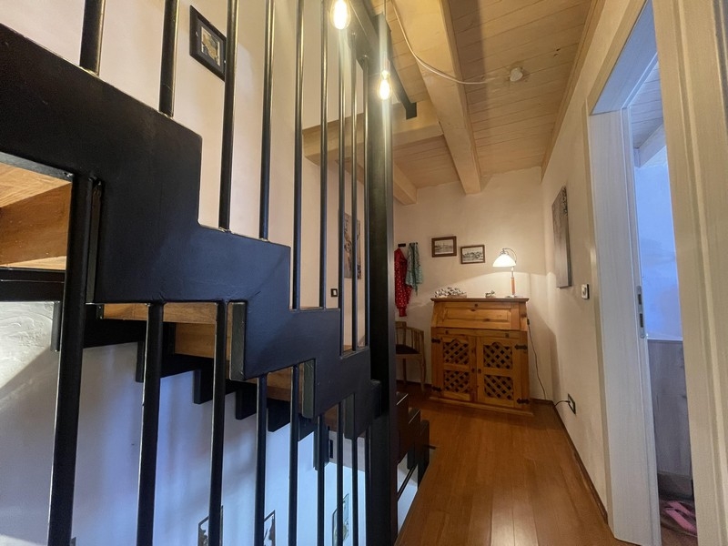 Escalier avec rampe métallique et couloir à l'étage