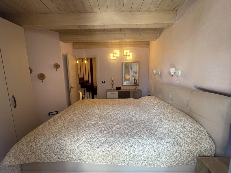 Chambre avec lit double et plafond à poutres en bois