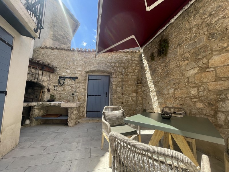 Cour intérieure avec grill maçonné et store
