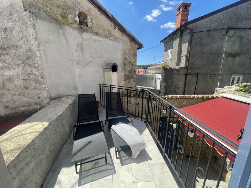 Terrasse avec chaises longues et vue sur les toits de Krk