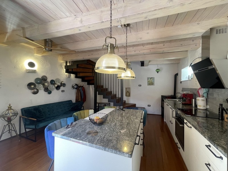 Cuisine avec îlot de cuisson en granit et plafond à poutres en bois