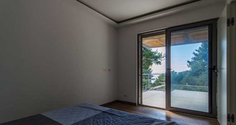 Chambre avec grande porte coulissante vitrée donnant sur l'extérieur