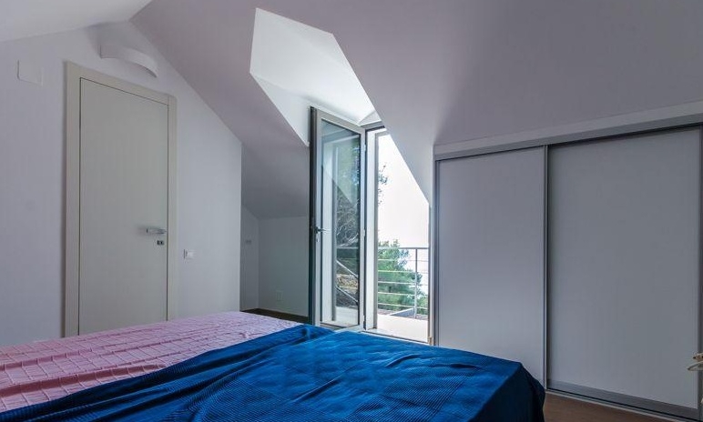 Chambre sous les combles avec porte donnant sur le balcon