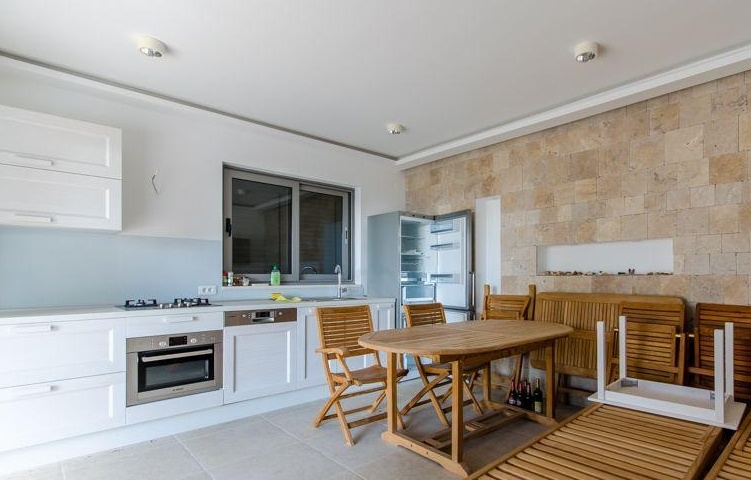 Cuisine avec espace repas et mur en pierre naturelle