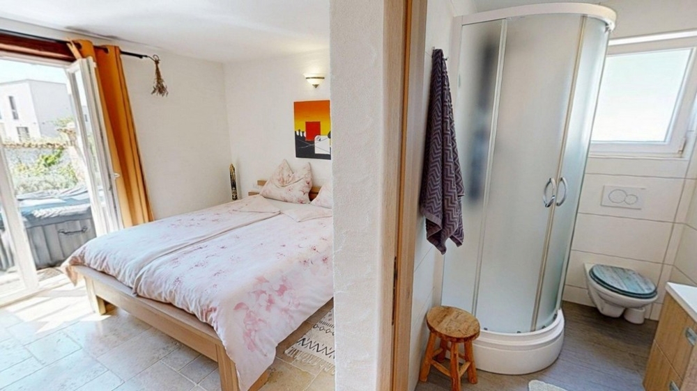 Chambre avec lit double et accès à la salle de bains