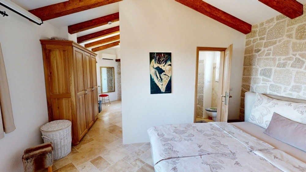 Chambre avec plafond à poutres en bois à l'étage