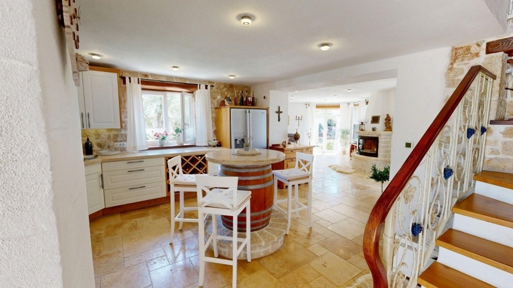 Cuisine avec îlot de cuisson et escalier vers l'étage