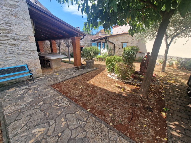 Terrasse couverte et jardin de la maison en pierre