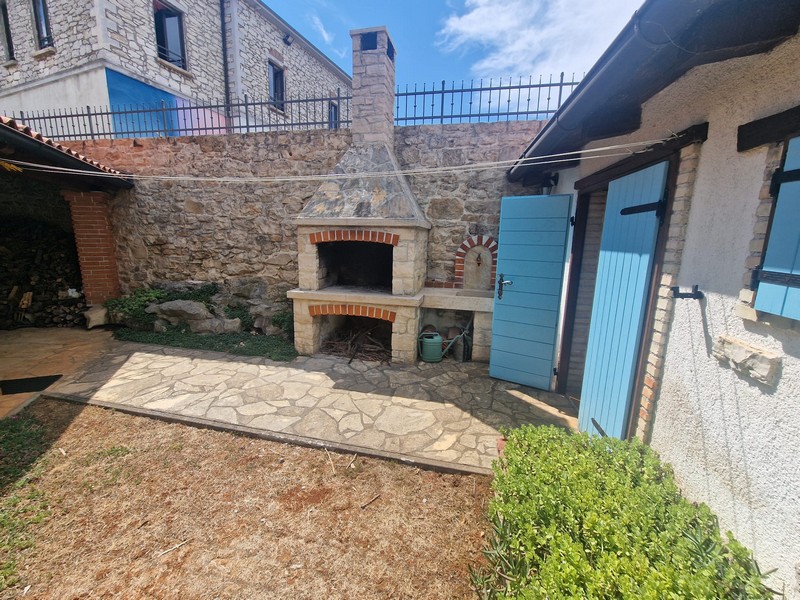 Cour intérieure avec coin barbecue et façade en pierre