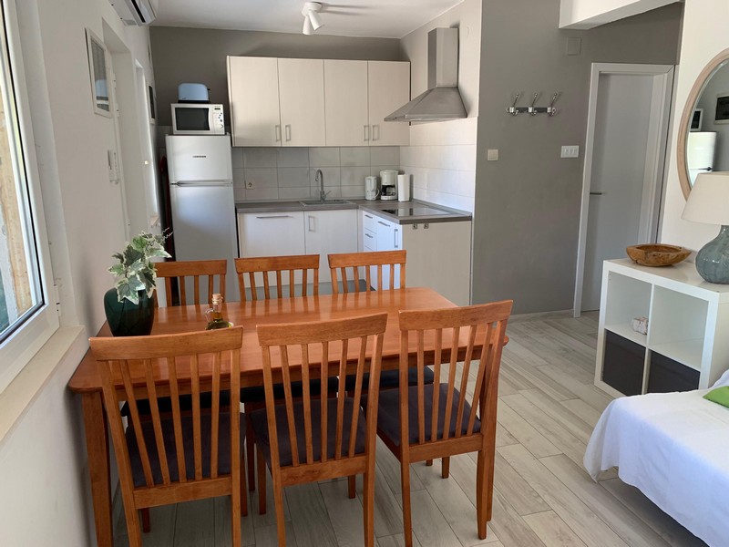 Cuisine avec table à manger dans un appartement de la maison à Povlja sur Brac