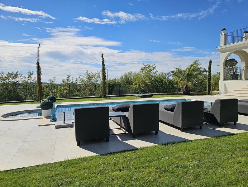 Terrasse de la piscine avec mobilier lounge et pelouse de la villa à Buje