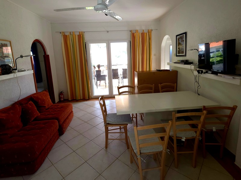 Séjour et espace repas avec table à manger et porte donnant sur la terrasse