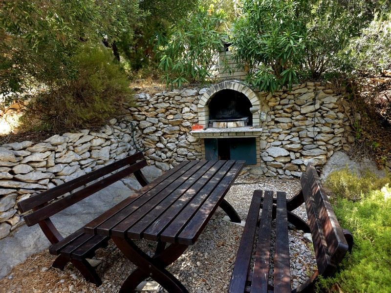 Coin barbecue avec cheminée extérieure maçonnée dans le jardin