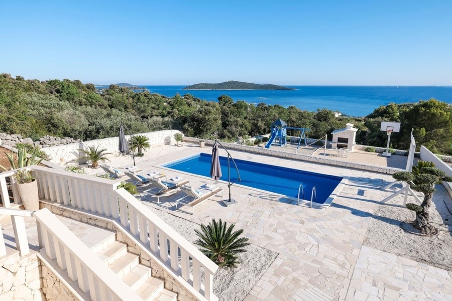 Piscine avec transats et vue sur la mer