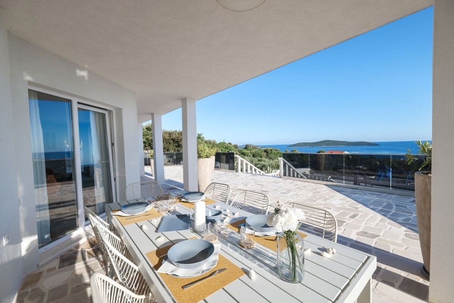Terrasse couverte avec table à manger au bord de la piscine