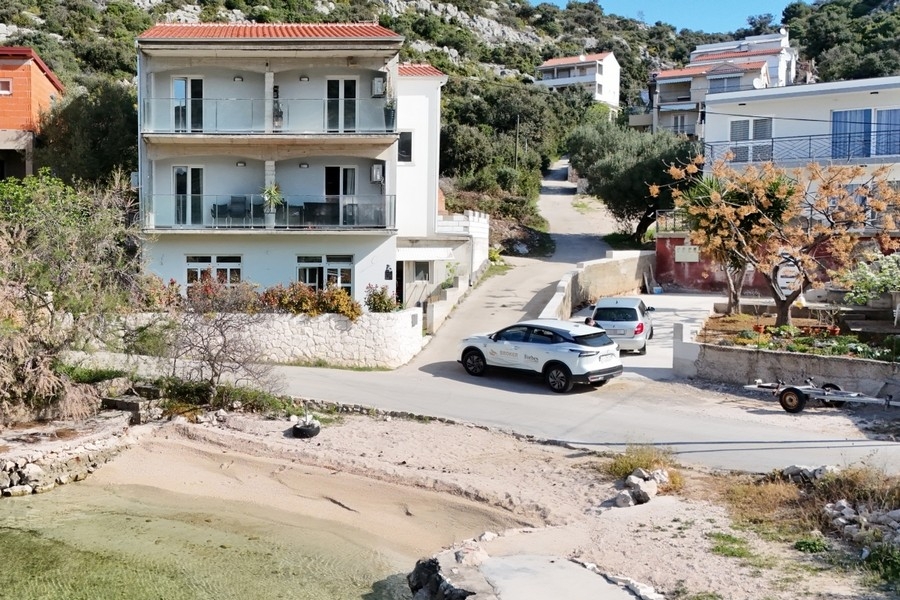 Immeuble collectif de trois étages avec balcons directement sur la baie