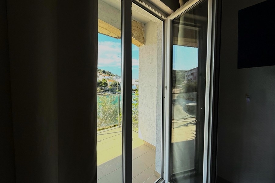 Chambre avec fenêtre à hauteur d'étage et vue sur la baie
