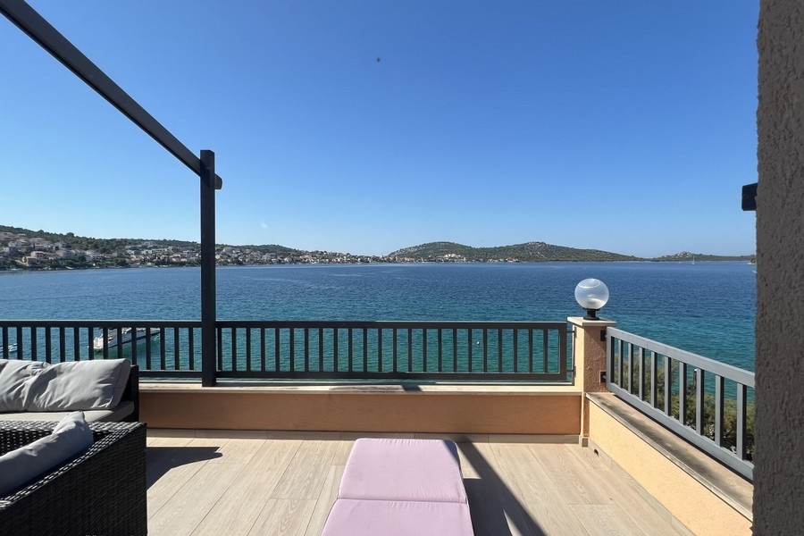 Terrasse avec lounge et vue sur la baie jusqu'au village