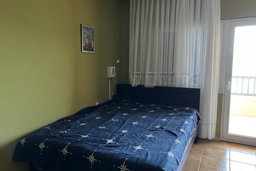 Chambre avec lit double et porte donnant sur le balcon