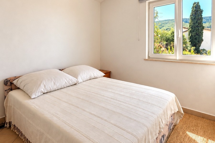 Chambre lumineuse avec lit double et vue sur la verdure