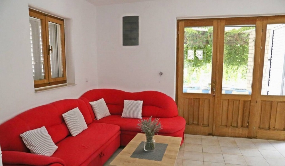 Salon avec canapé et porte donnant sur la terrasse