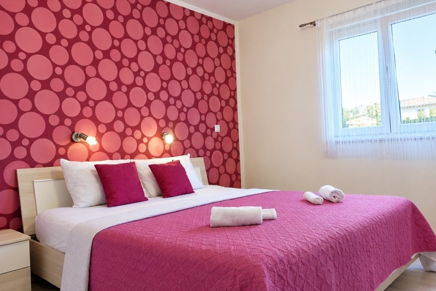 Chambre avec lit double et mur à motifs