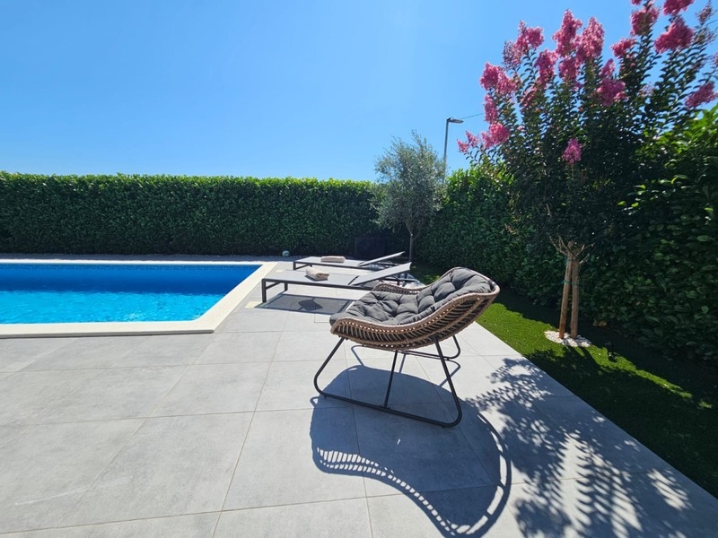 Piscine avec plage et transats