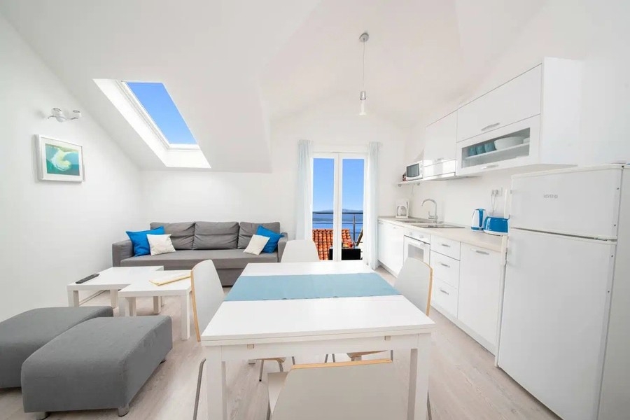 Séjour ouvert avec cuisine et vue vers le balcon