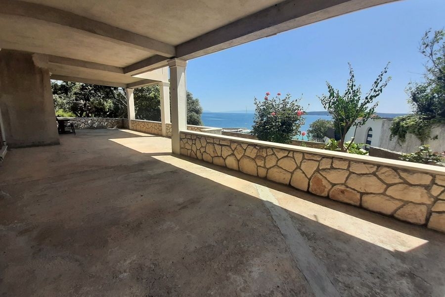 Grande terrasse avec mur en pierre naturelle et vue mer