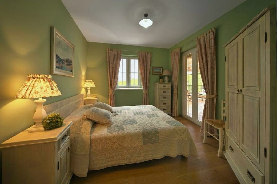 Chambre avec lit double et murs verts