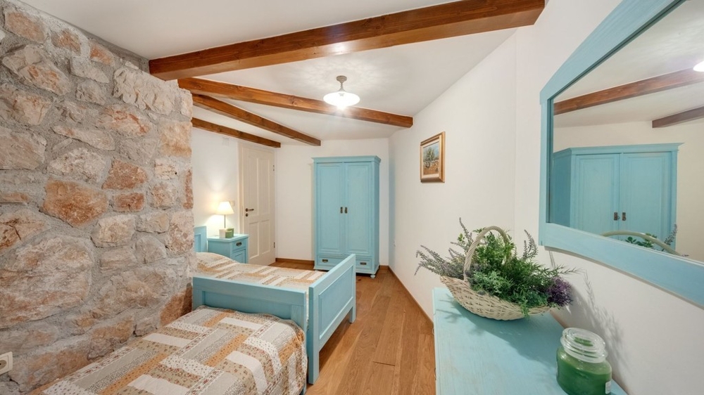 Pièce avec mur en pierre naturelle et lit simple