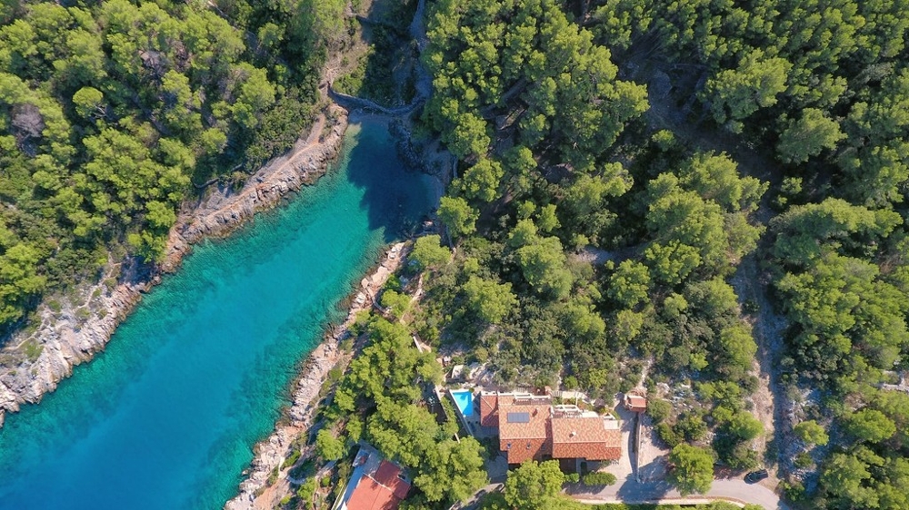 Vue aérienne de la baie avec la maison dans la forêt de pins