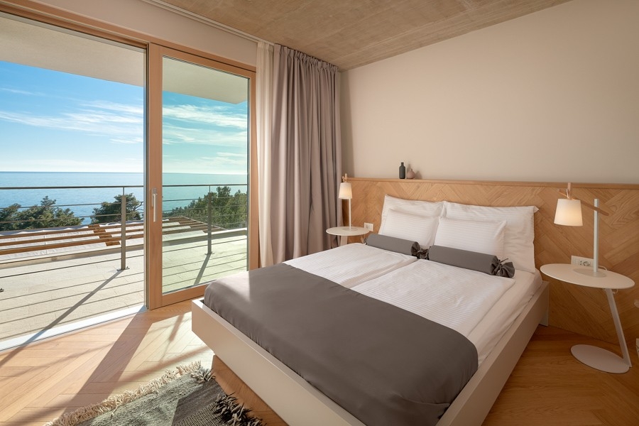 Chambre avec grande baie vitrée et vue mer